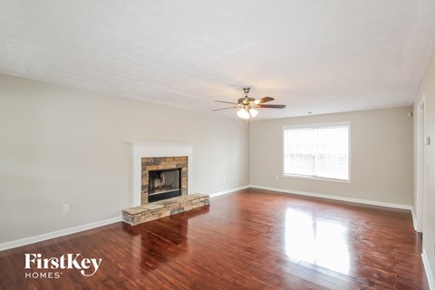 a living room with a fireplace and a ceiling fan