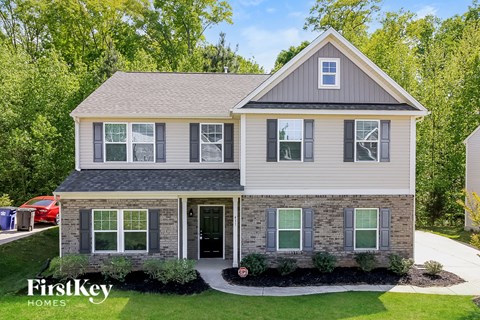 a renovated home with a stone and gray exterior and a gray roof