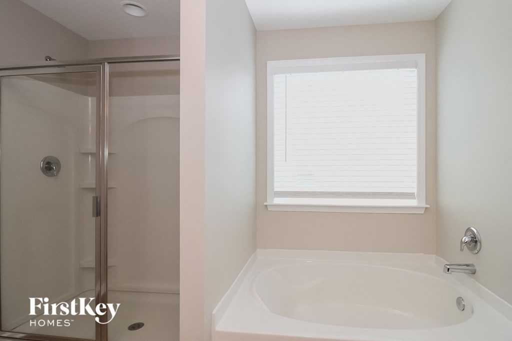 a bathroom with a tub and a shower and a window