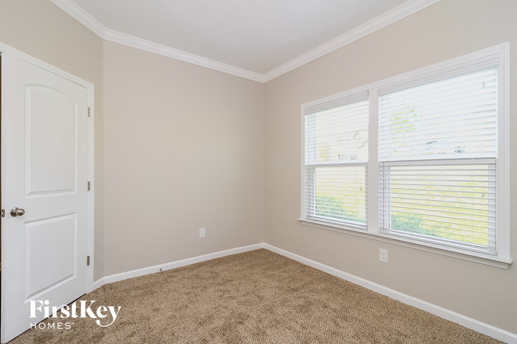 a bedroom with a carpeted floor and two windows