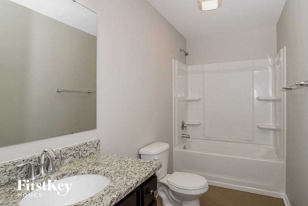 a bathroom with a shower toilet and sink and a mirror