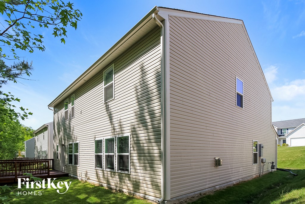 side view of the back of a house with vinyl siding and windows