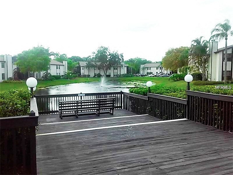 a wooden bridge over a pond with a bench