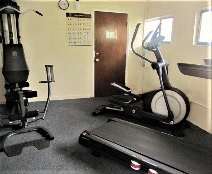 a gym with exercise equipment in a room with a door