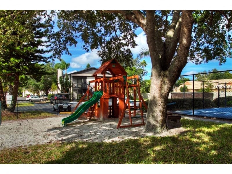 a playground with a swing set next to a tree