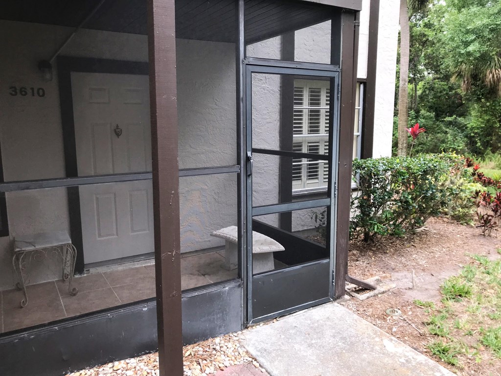 the outside of a screened in porch of a house