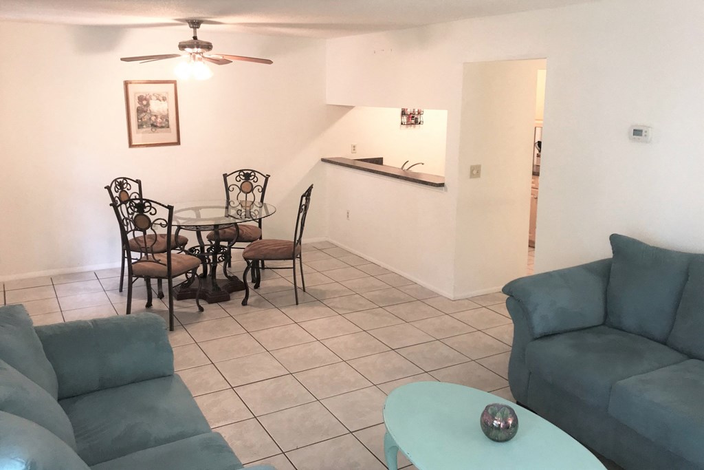 a living room with couches and a table and a kitchen