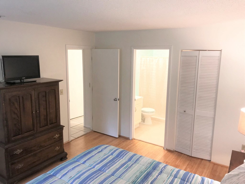 a bedroom with a bed and a bathroom with a toilet