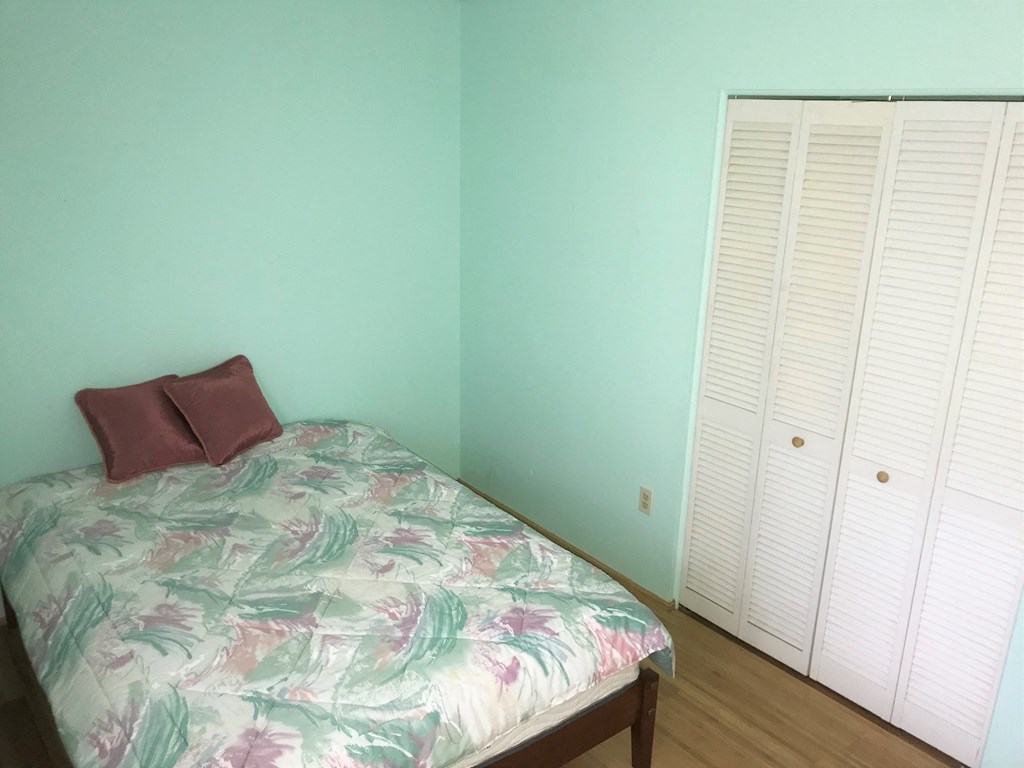 a bedroom with a bed and a blue wall and a closet