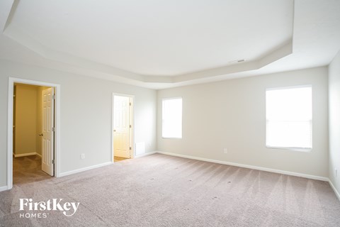 the living room of a new home with white walls and carpet