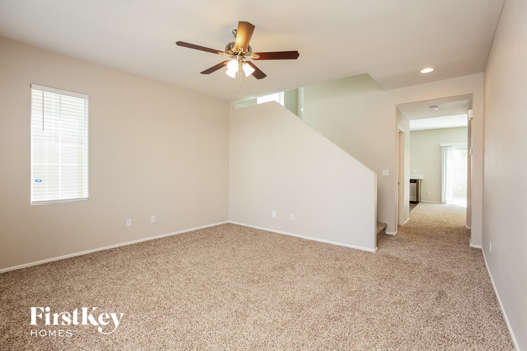 the master bedroom has a carpeted floor and a ceiling fan