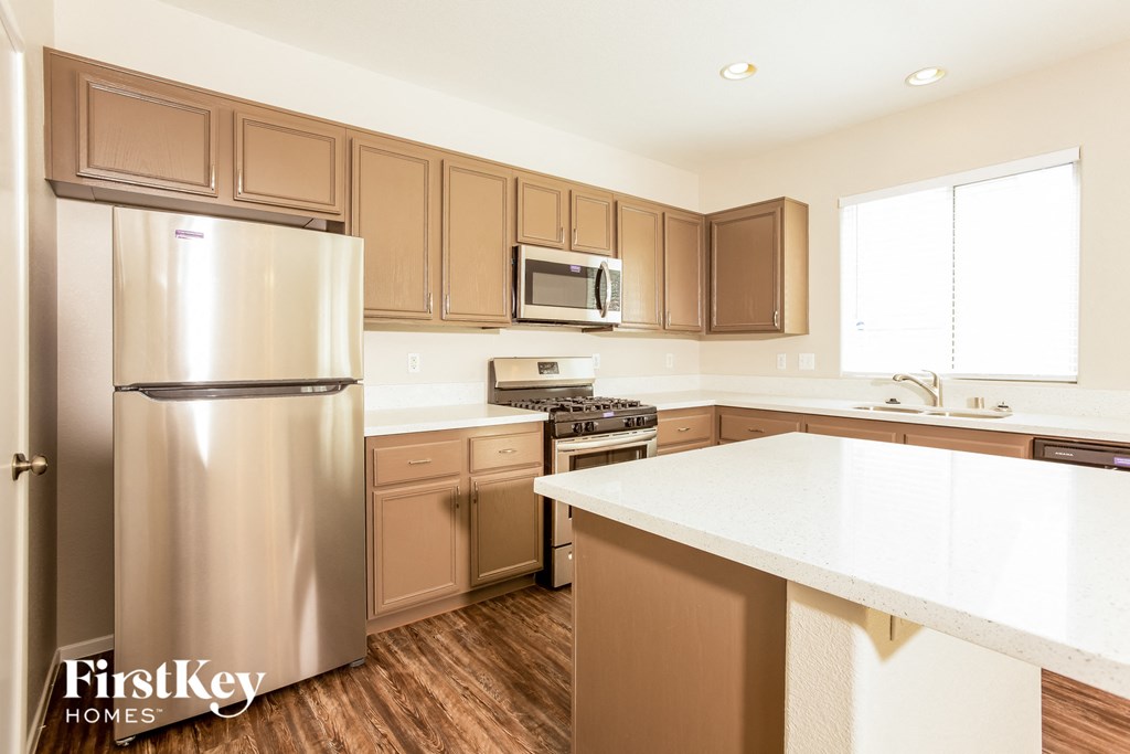 a kitchen with stainless steel appliances and white countertops