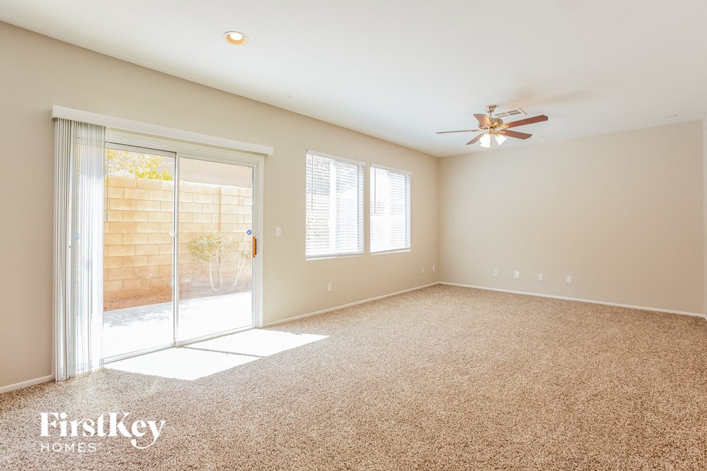 an empty living room with a sliding glass door to a patio