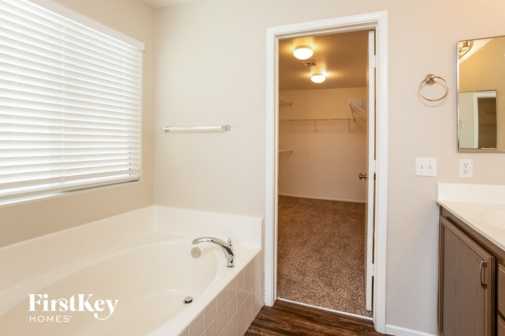 a bathroom with a tub and a sink and a mirror