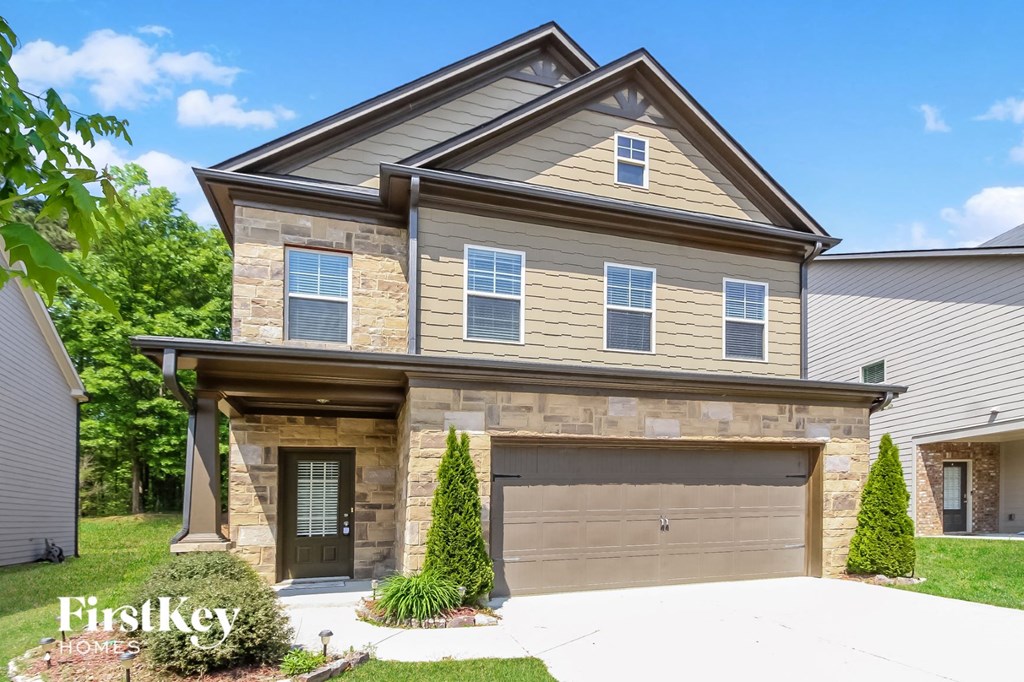 a tan and brown house with a garage door
