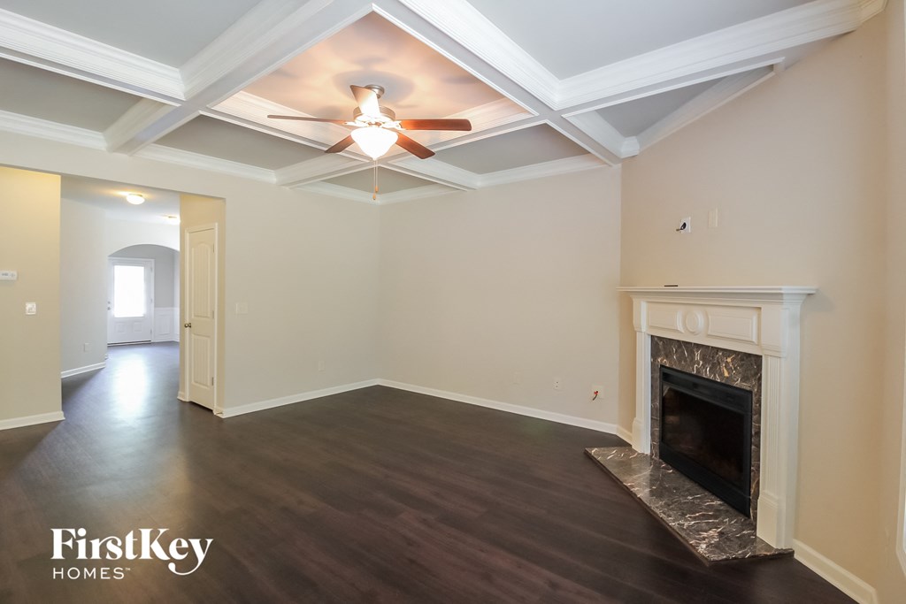 a living room with a fireplace and a ceiling fan