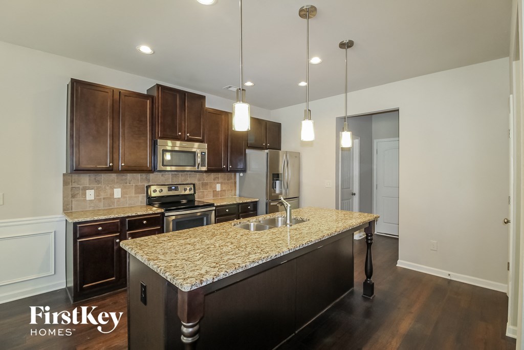 a kitchen with a granite counter top and wooden cabinets