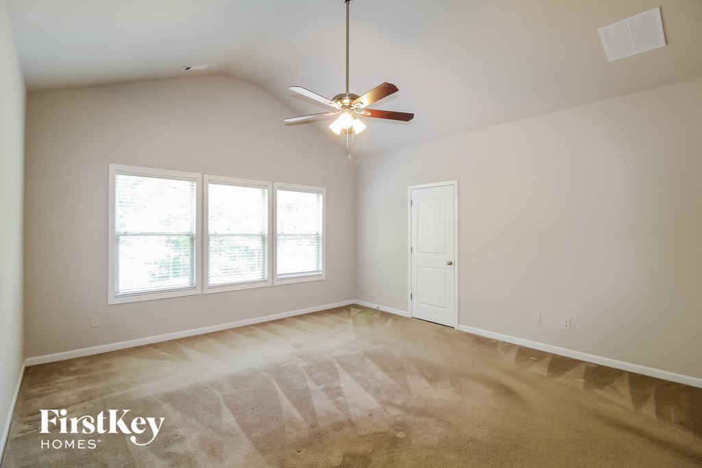 a living room with a ceiling fan and a large window