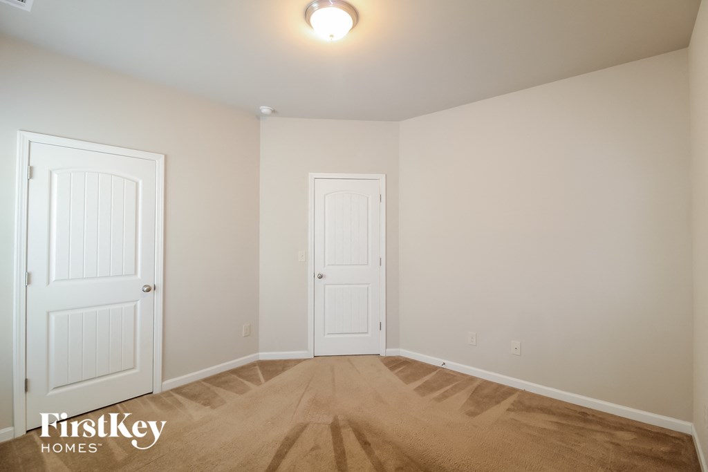 a bedroom with two white doors and a wooden floor