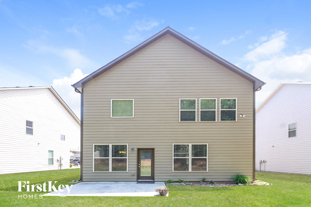 front view of a tan house with green grass