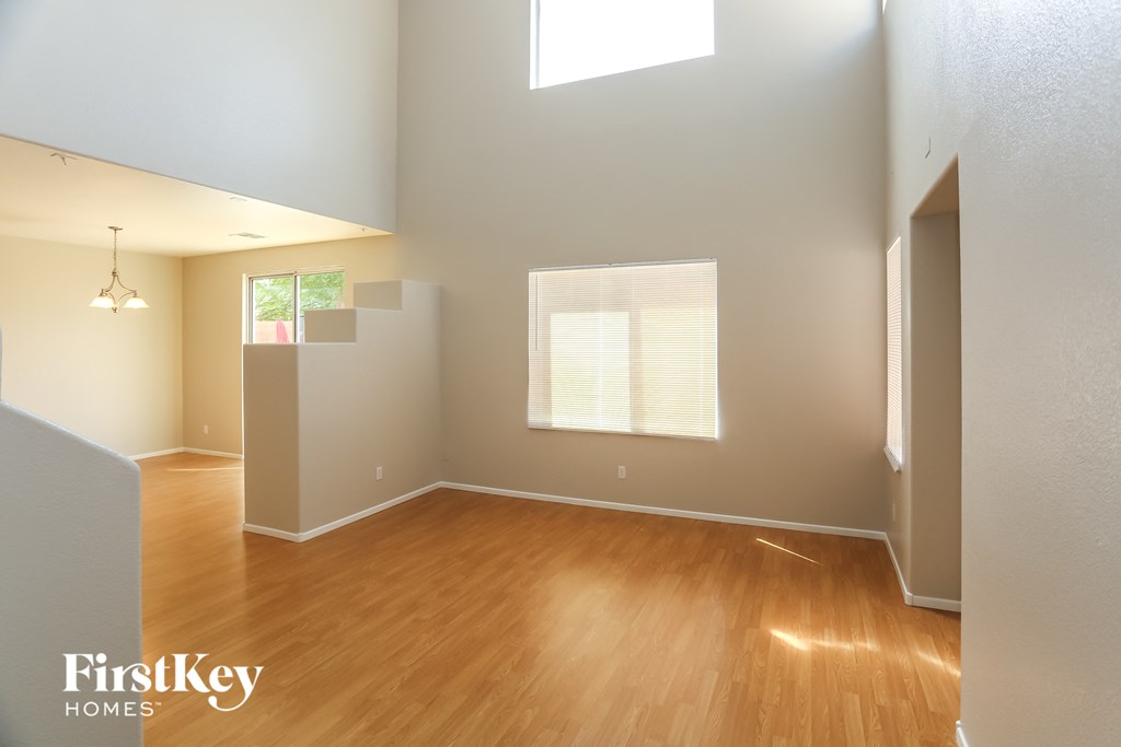 A room with wooden floors and a window with blinds.