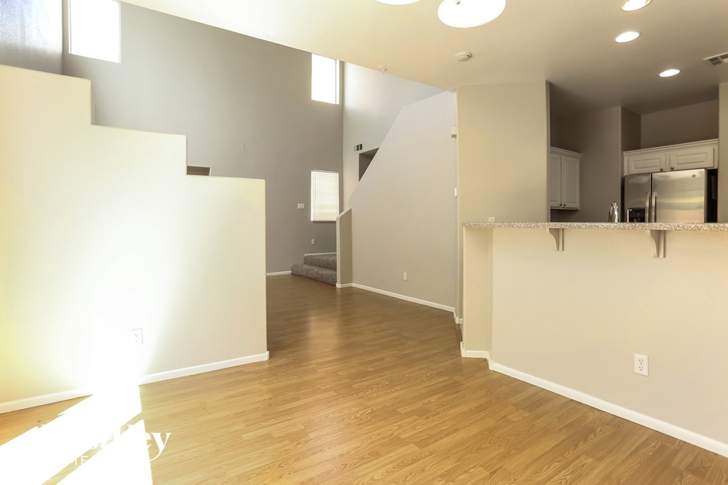 A spacious living room with a staircase on the left side.