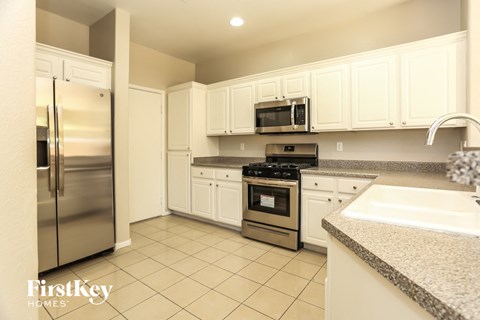 A kitchen with white cabinets and appliances.