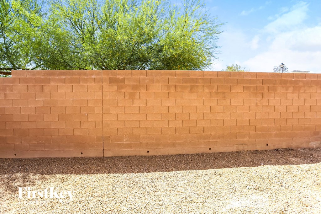 A wall made of bricks with trees in the background.