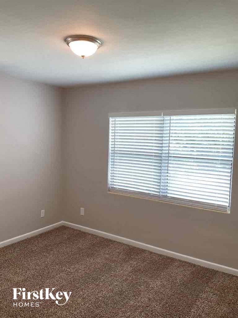 an empty room with a window and a lamp on the ceiling