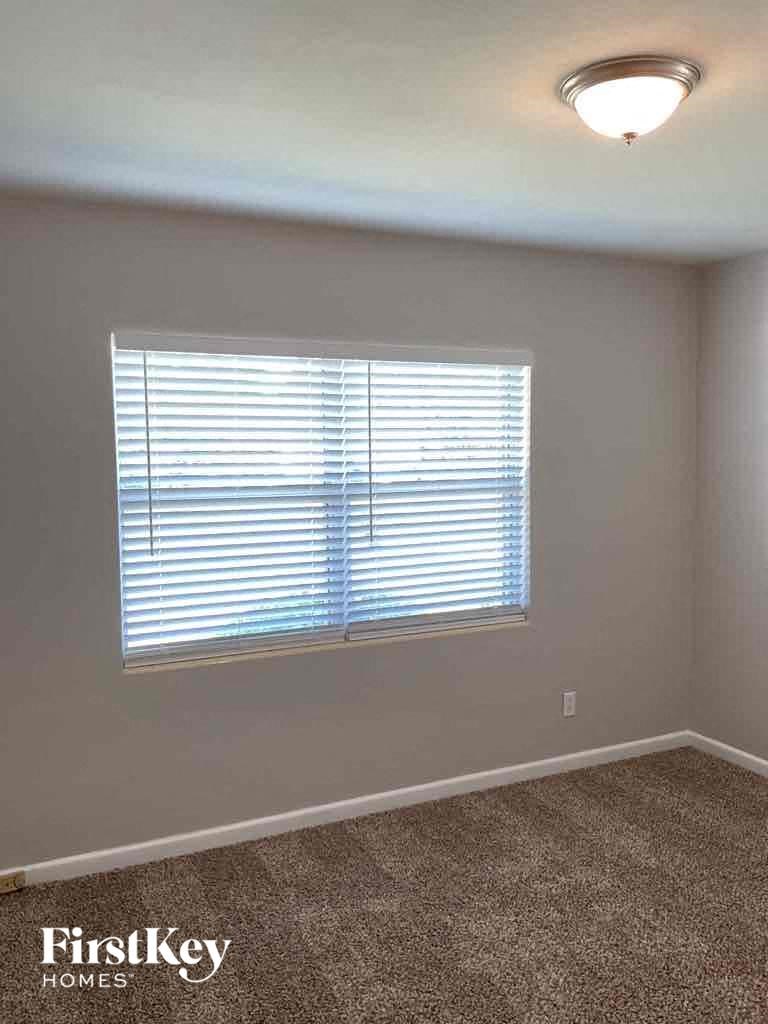an empty living room with a window and a carpet