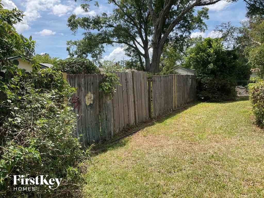a backyard with a fence and a tree