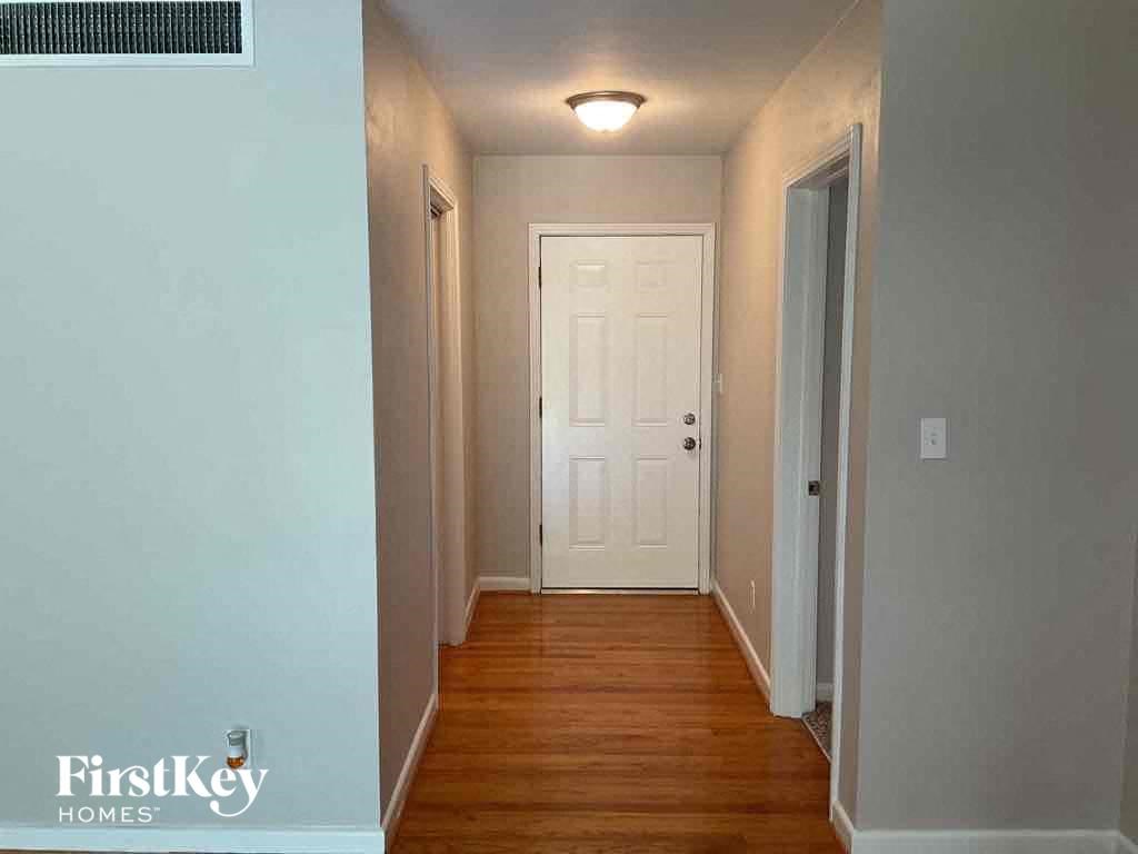 a hallway with wood floors and a white door