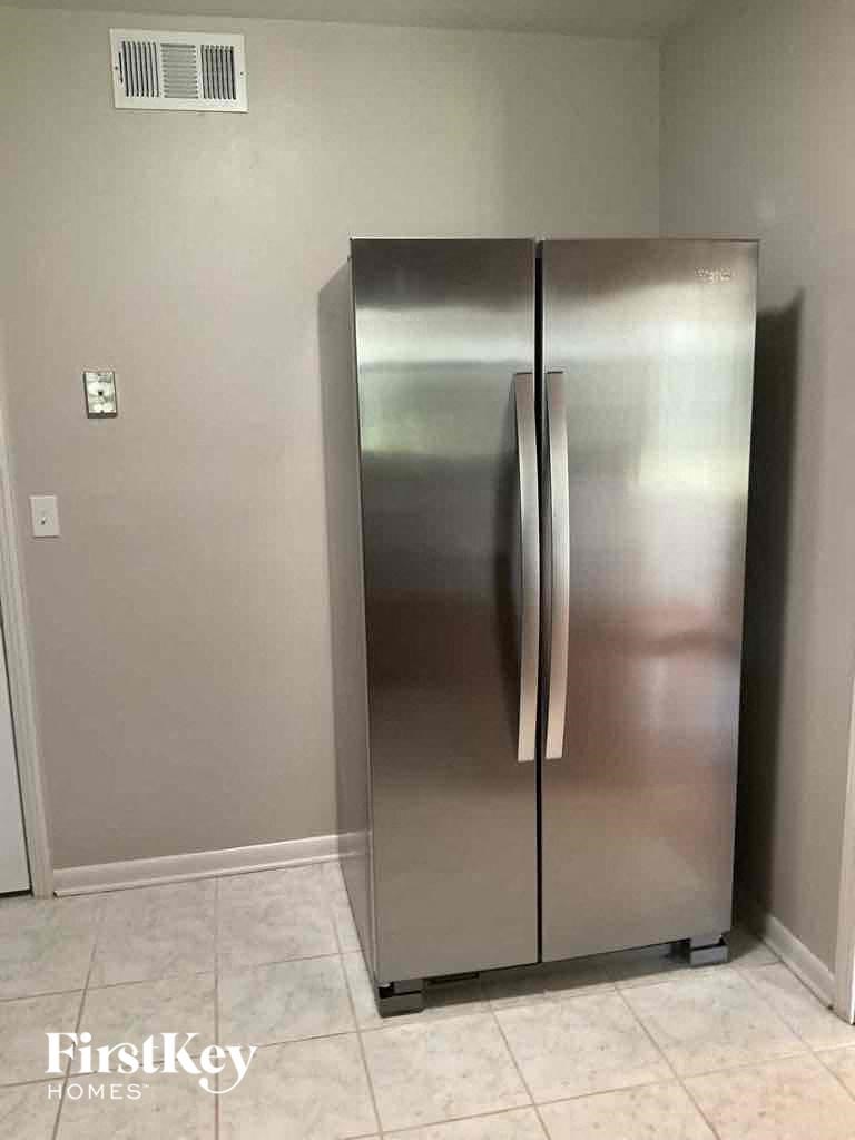 a stainless steel refrigerator in the corner of a room