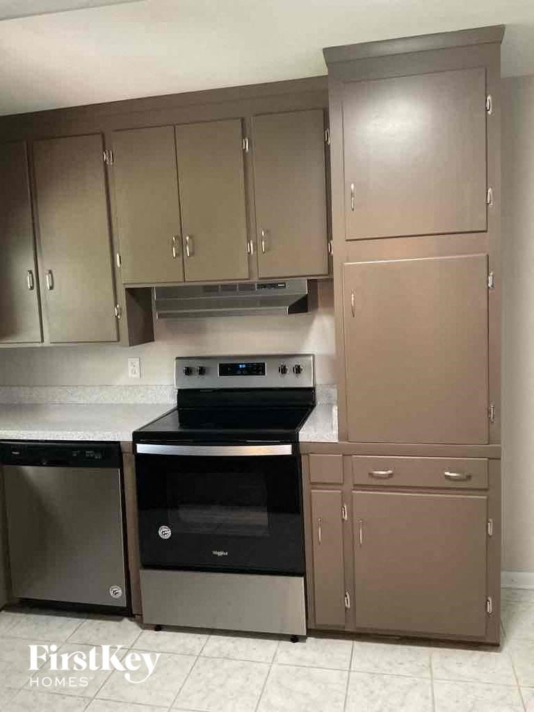 an empty kitchen with stainless steel cabinets and a black stove