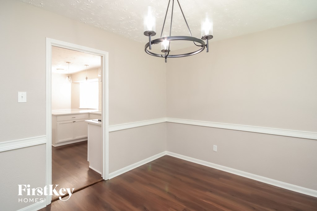 A well-lit room with a chandelier and a doorway leading to another room.