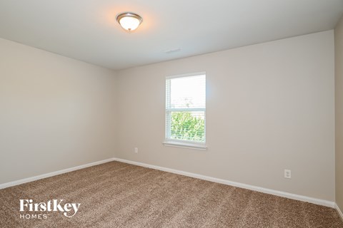 the second bedroom is spacious and has carpeting and a window