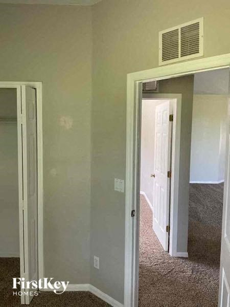 A room with a carpeted floor and a doorway leading to another room.