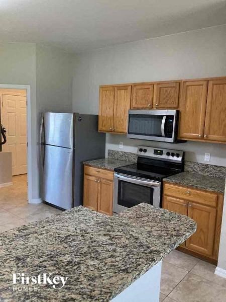 A kitchen with granite countertops and wooden cabinets.