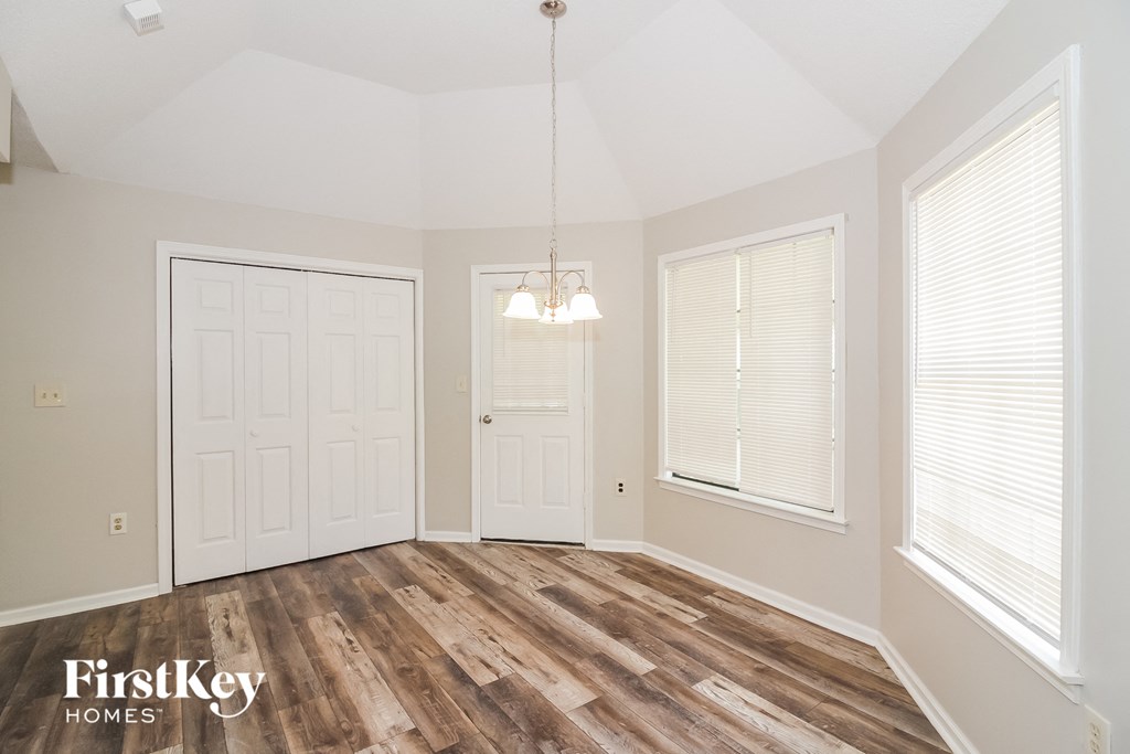 A room with wooden floors and a chandelier hanging from the ceiling.