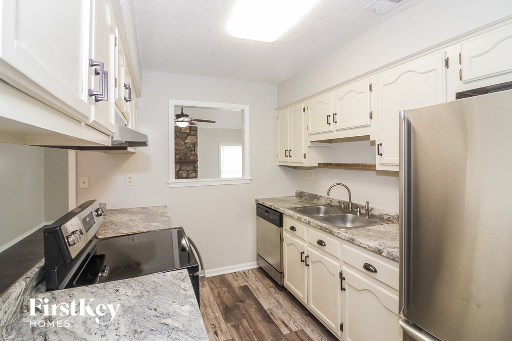 A kitchen with a sink, stove, and refrigerator.