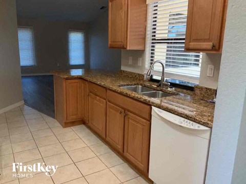 A kitchen with wooden cabinets and a granite countertop.