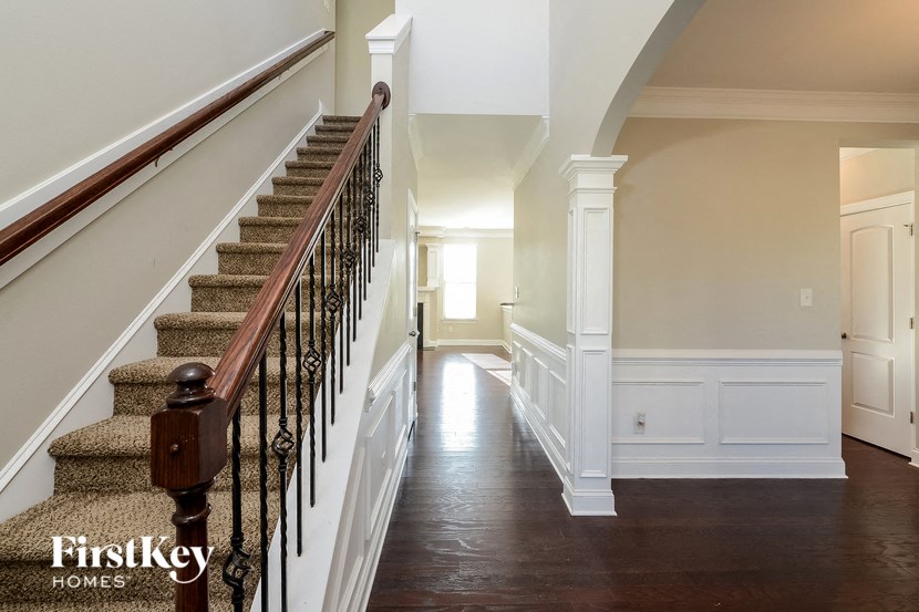 a staircase in a home with white walls and a wood floor