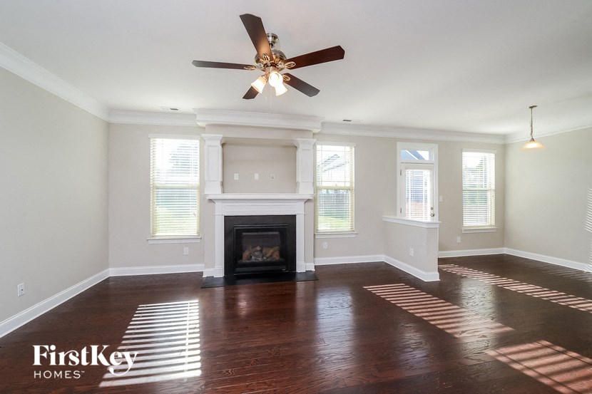 a living room with a fireplace and a ceiling fan