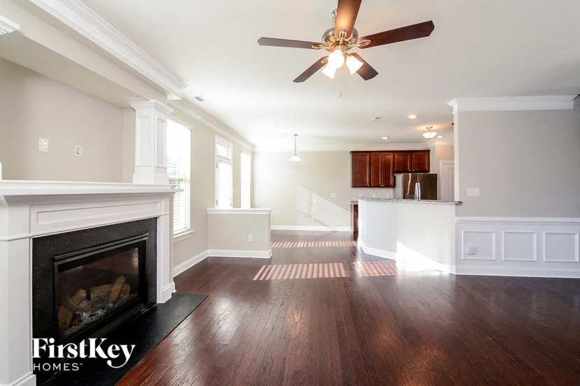 a living room with a fireplace and a ceiling fan