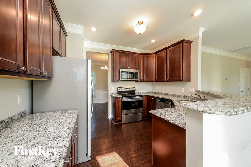 a kitchen with wooden cabinets and granite counter tops and a stainless steel appliances