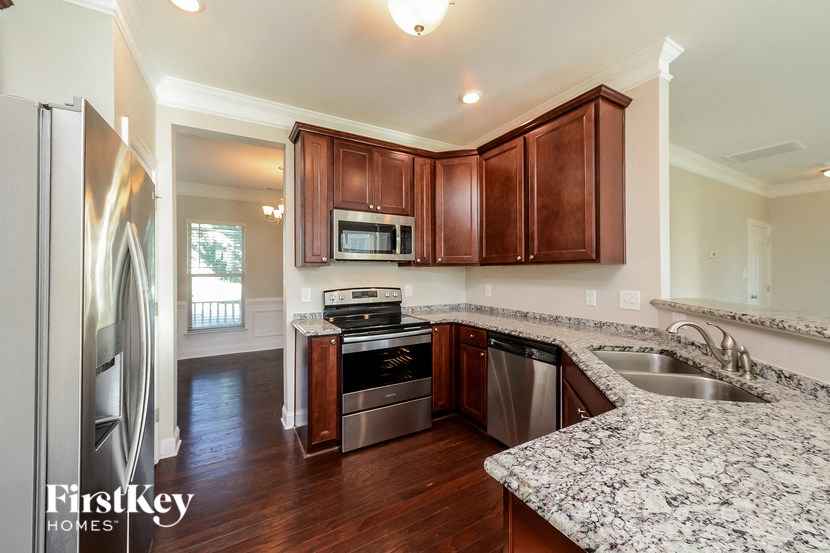 a kitchen with wooden cabinets and granite counter tops and stainless steel appliances