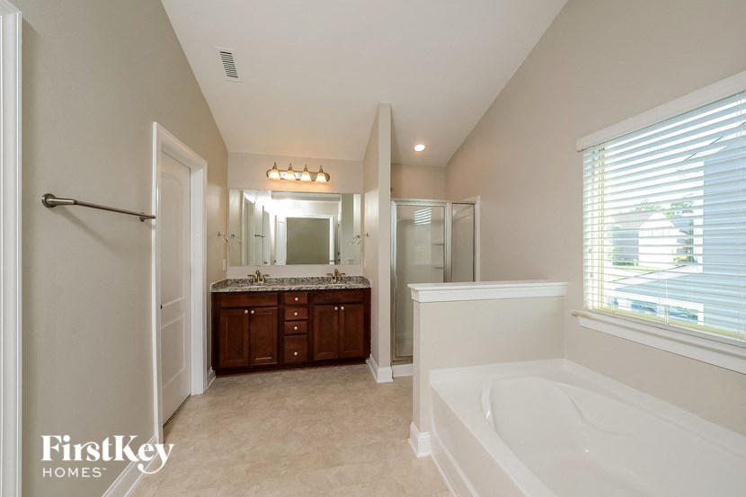 a bathroom with a large tub and a sink and a shower