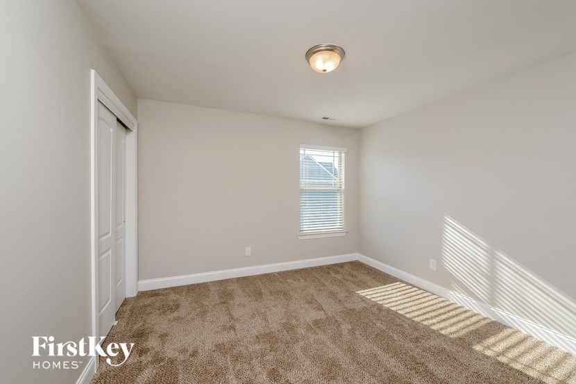 a spacious bedroom with carpet and a door to a closet