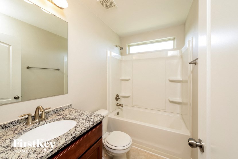 a bathroom with a white tub and sink and a toilet