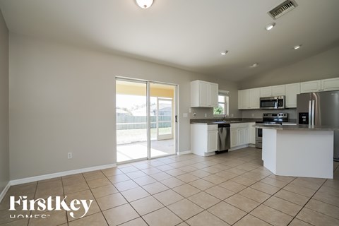 A spacious kitchen with white cabinets and appliances.